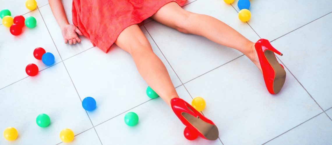 Unconscious woman lying on stomach on the floor with many colored balls.